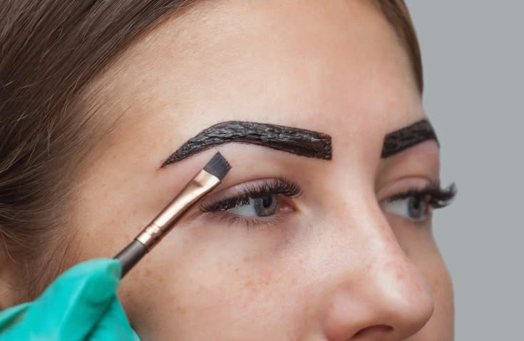 Professional henna eyebrow tinting application by skilled aestheticians