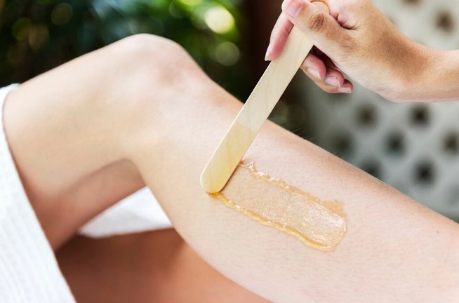 Spreading soothing wax formula during hair removal treatment at Bay Ridge salon