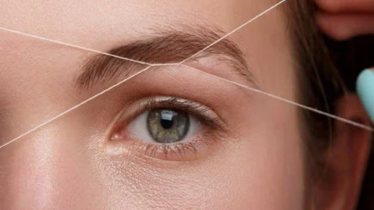 Hair threading session in a Brooklyn salon with a technician and client, emphasizing precision and hygiene